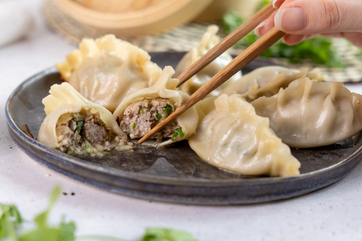 Chinesische Dumplings mit Stäbchen essen
