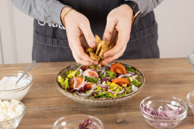Hähnchen auf den Salat geben