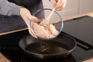 Hähnchen in Pfanne geben