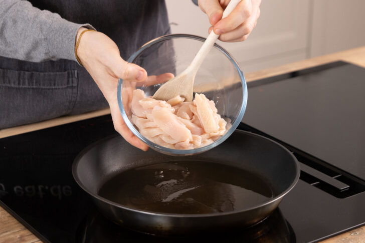 Hähnchen in Pfanne geben
