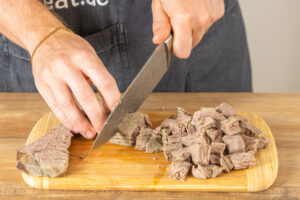 Rindfleisch in mundgerechte Würfel schneiden.