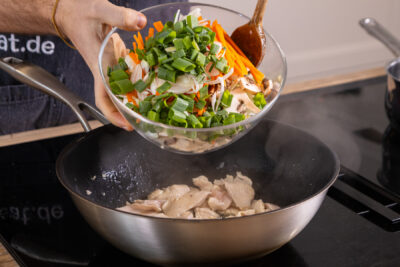 Gemüse in den Wok geben
