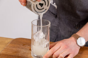 Gin Fizz aus Shaker gießen