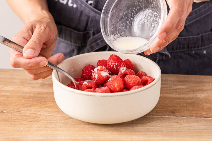 angerührte Speisestärke zu Himbeeren gießen