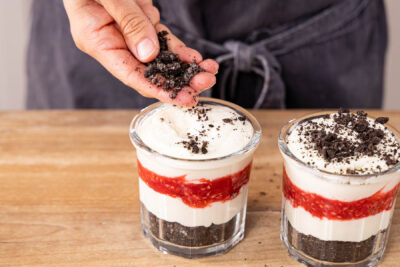 Kekskrümel auf das Himbeer Oreo Dessert geben