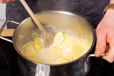 Kartofferlscheiben in Sahne vorkochen