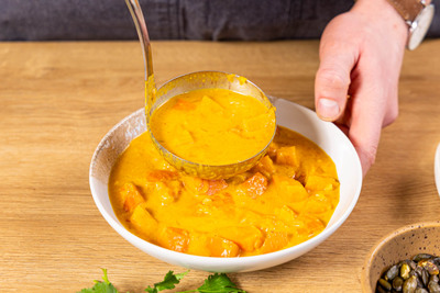 Kürbis Curry mit Kokosmilch anrichten