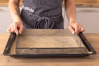 Backblech mit Backrahmen und Backpapier vorbereiten