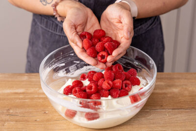 Sahne und Himbeeren unter den Quark rühren