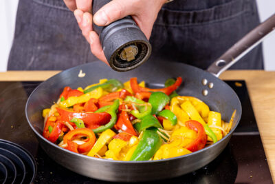 Mediterranes Paprikagemüse mit Salz und Pfeffert würzen