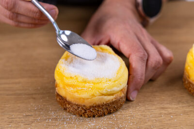 Mini-Crème-brûlée-Käsekuchen mit Zucker bestreuen