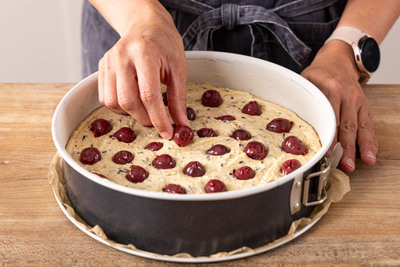 abgetropfte Sauerkirschen auf den Rührteig legen