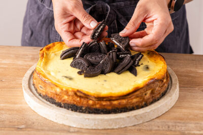 Oreo Cheesecake mit Keksstücken dekorieren
