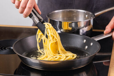 Pasta aus dem Topf zur Salbeibutter in die Pfanne geben