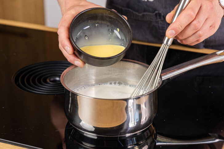 angerührtes Puddingpulver zur Milch geben