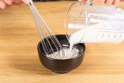 Milch zum Puddingpulver gießen