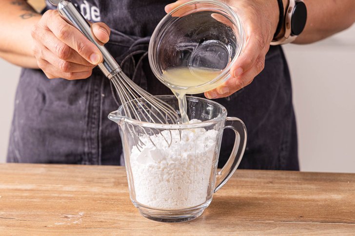 Zitronensaft zum Puderzucker geben