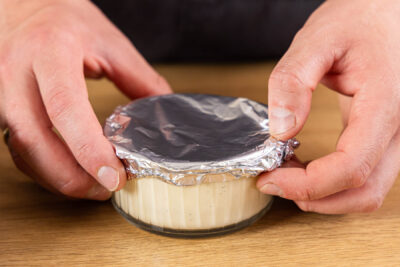 Gläser mit schneller Crème brûlée mit Alufolie abdecken