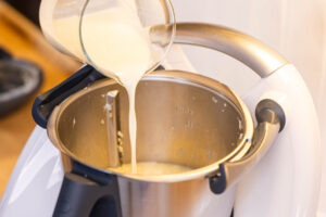 Sahne zur Selleriesuppe in den Thermomix® gießen
