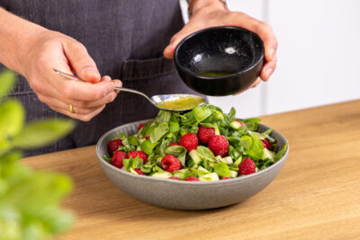 Sommersalat mit Dressing vermengen