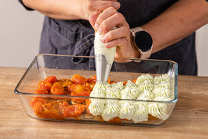 Basilikum auf die Tomatenschicht spritzen