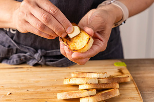 geröstete Brotscheiben mit Knoblauch einreiben