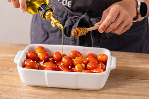 Öl und Honig zu den Tomaten geben