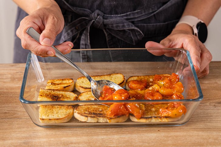 geröstete Tomaten auf geröstete Brotschicht geben