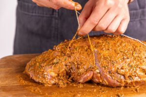 Wildschweinkeule mit Garn zusammenbinden