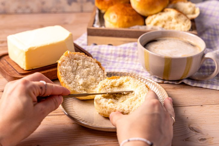 Hefebrötchen mit Butter bestreichen