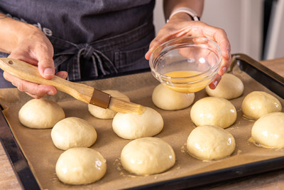 Teiglinge mit Eigelb bestreichen