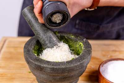 Pesto mit Gewürzen sowie Parmesan verfeinern