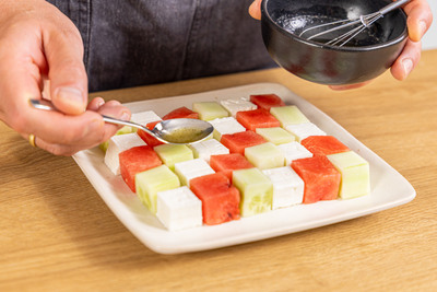 Dressing über den Salat geben
