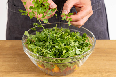 Rucola waschen, trocken schleudern und Petersilie zupfen