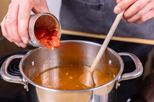 Gehackte Tomaten aus der Dose dazugeben