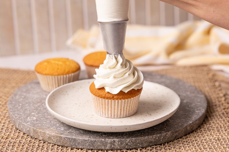 Buttercreme auf Cupcake spritzen