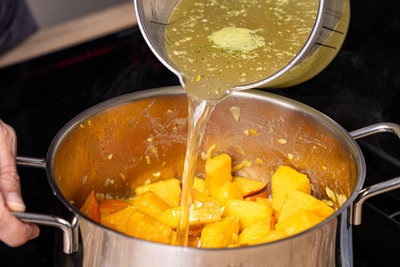 Gemüsebrühe in den Topf gießen und Kürbis darin weichkochen