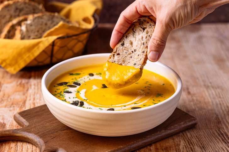 Kürbissuppe mit Brot essen
