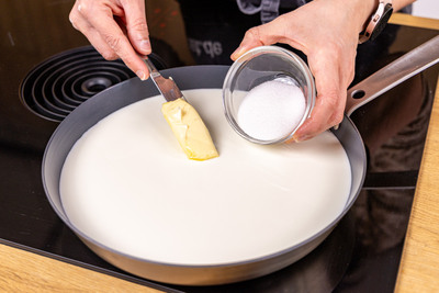 Milch mit Butter und Zucker in die Pfanne geben