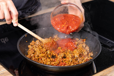 gehackte Tomaten zum Hackfleisch geben