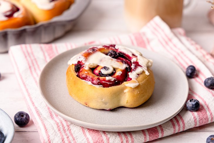 Blaubeerschnecke auf einem Teller mit Frosting serviert