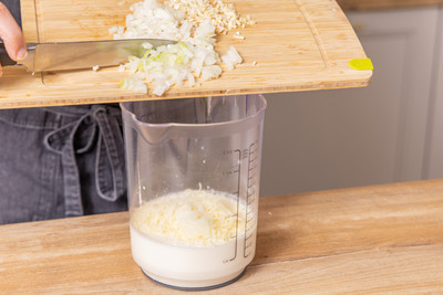 Knoblauch und Zwiebel zur Sahne geben