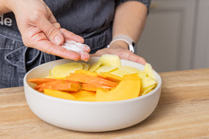 Kürbis und Kartoffel salzen