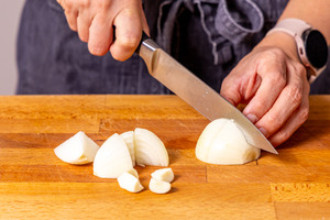 Zwiebel und Knoblauch vierteln