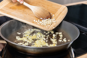 Knoblauch in die Pfanne geben