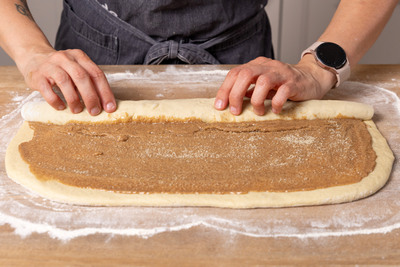Teig mit Zimtschneckenfüllung aufrollen